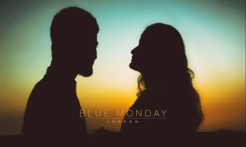 a man and a woman looking at each other with a sunset in the background