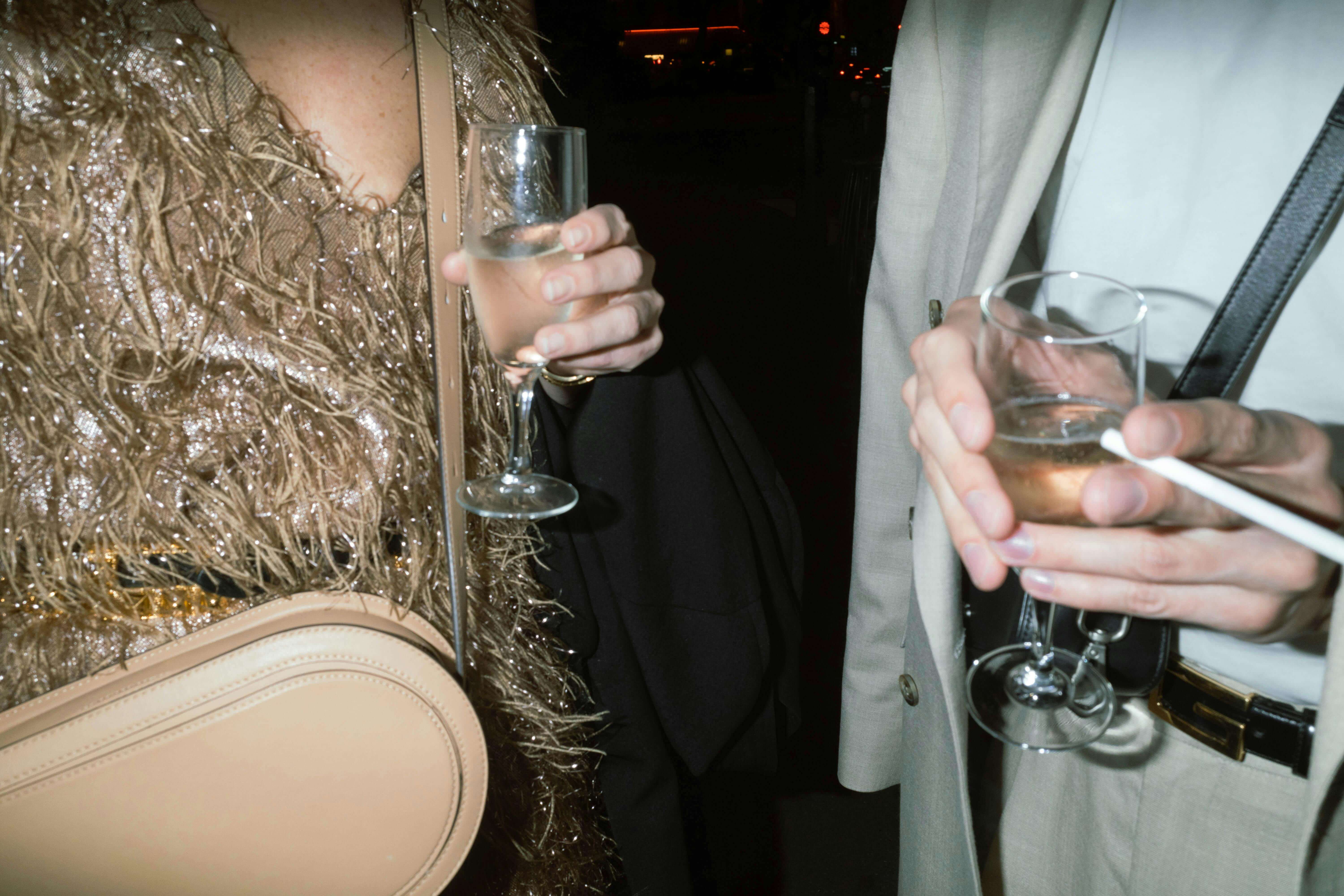 an elite escort and her client holding drinks at a party