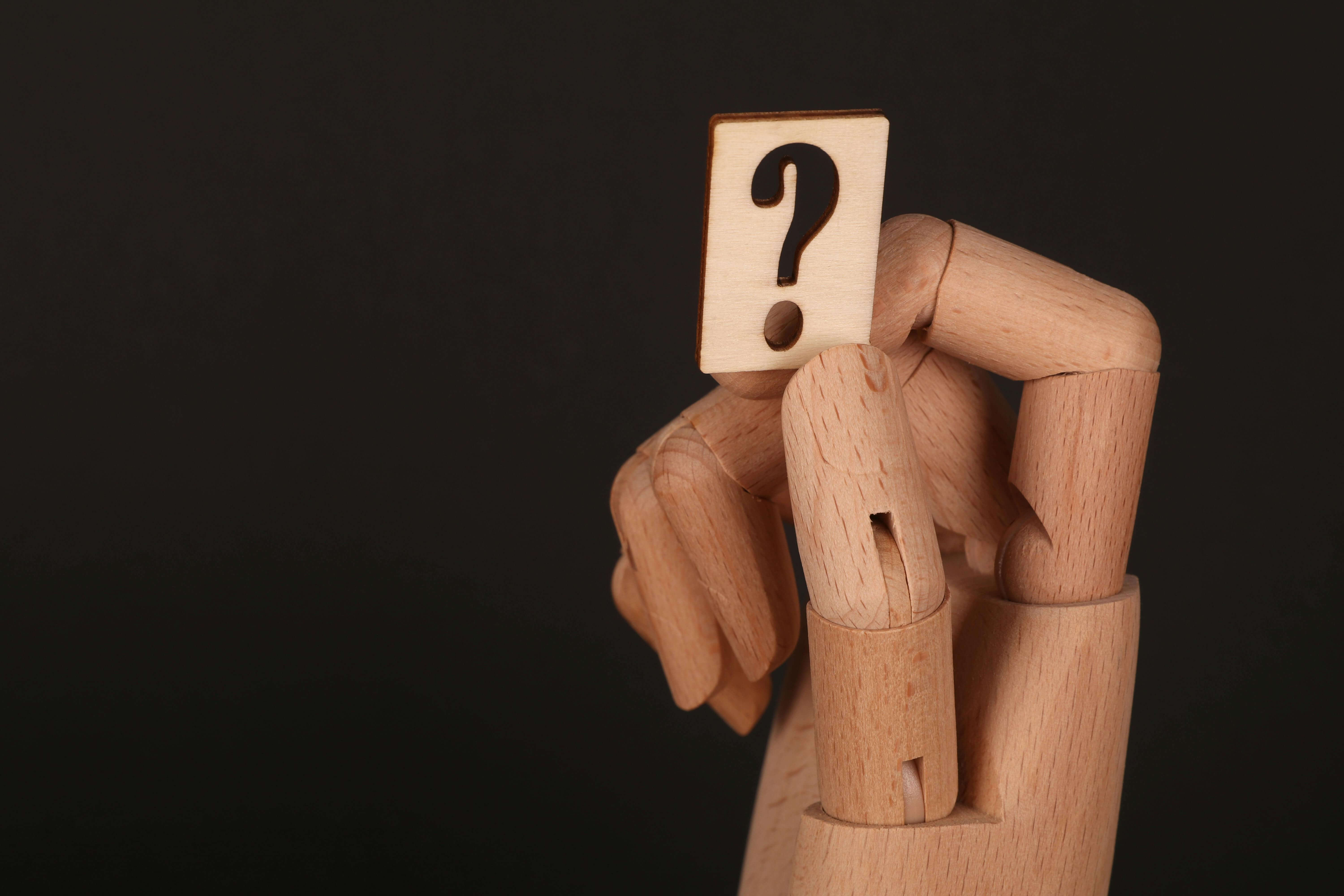 a question mark in a wooden hand
