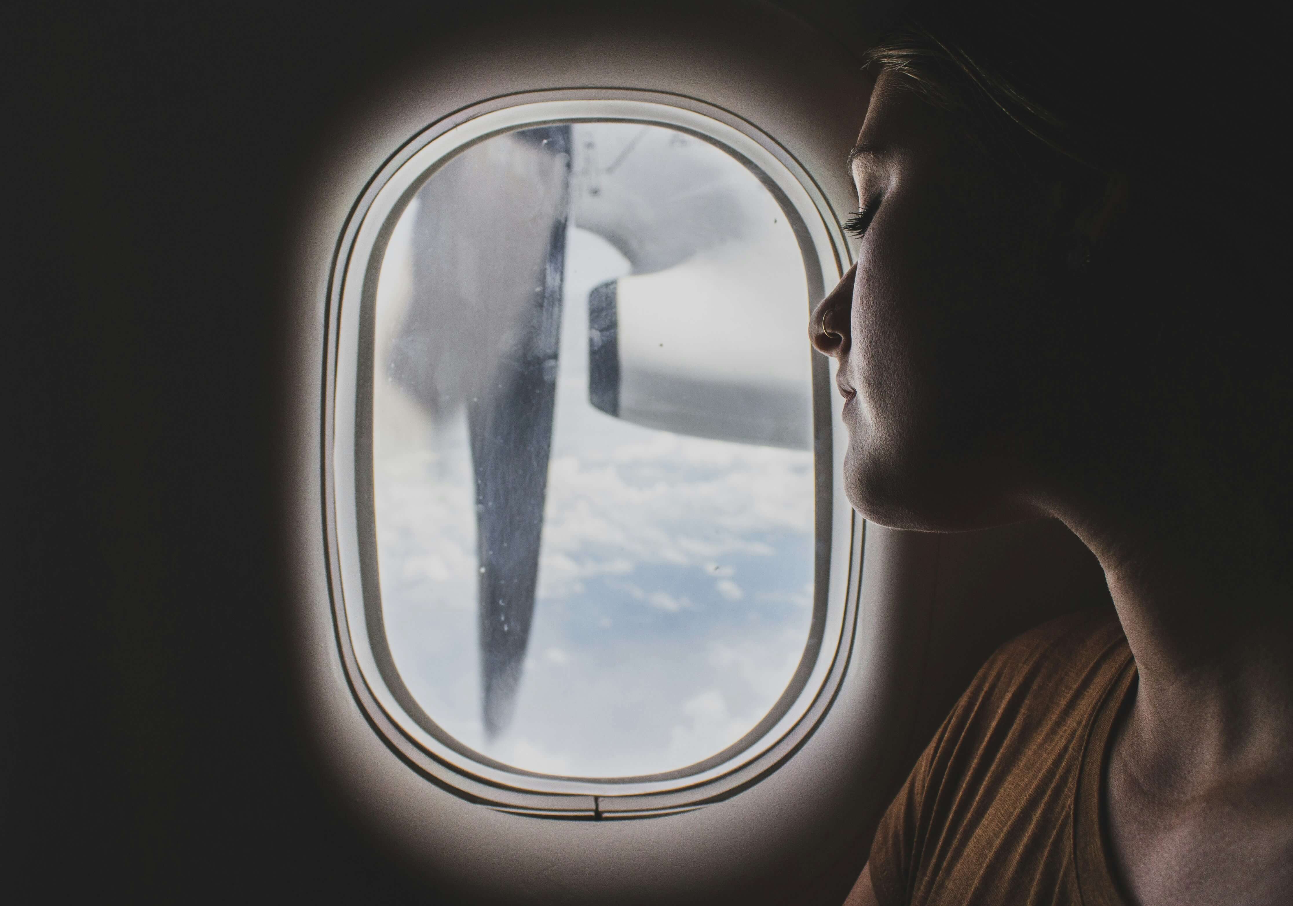 a woman looking out of a plane window