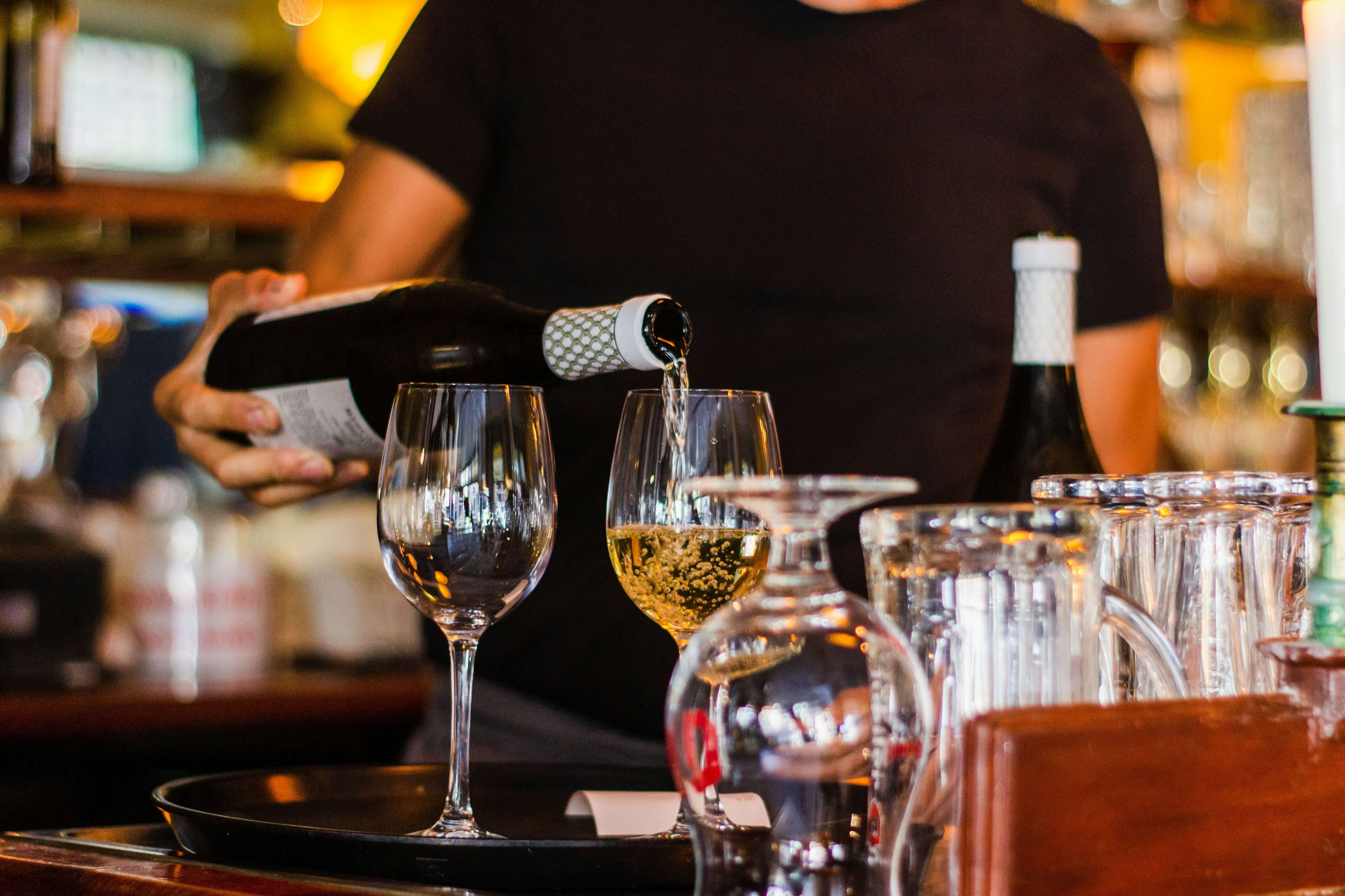 a bartender pouring a glass of wine