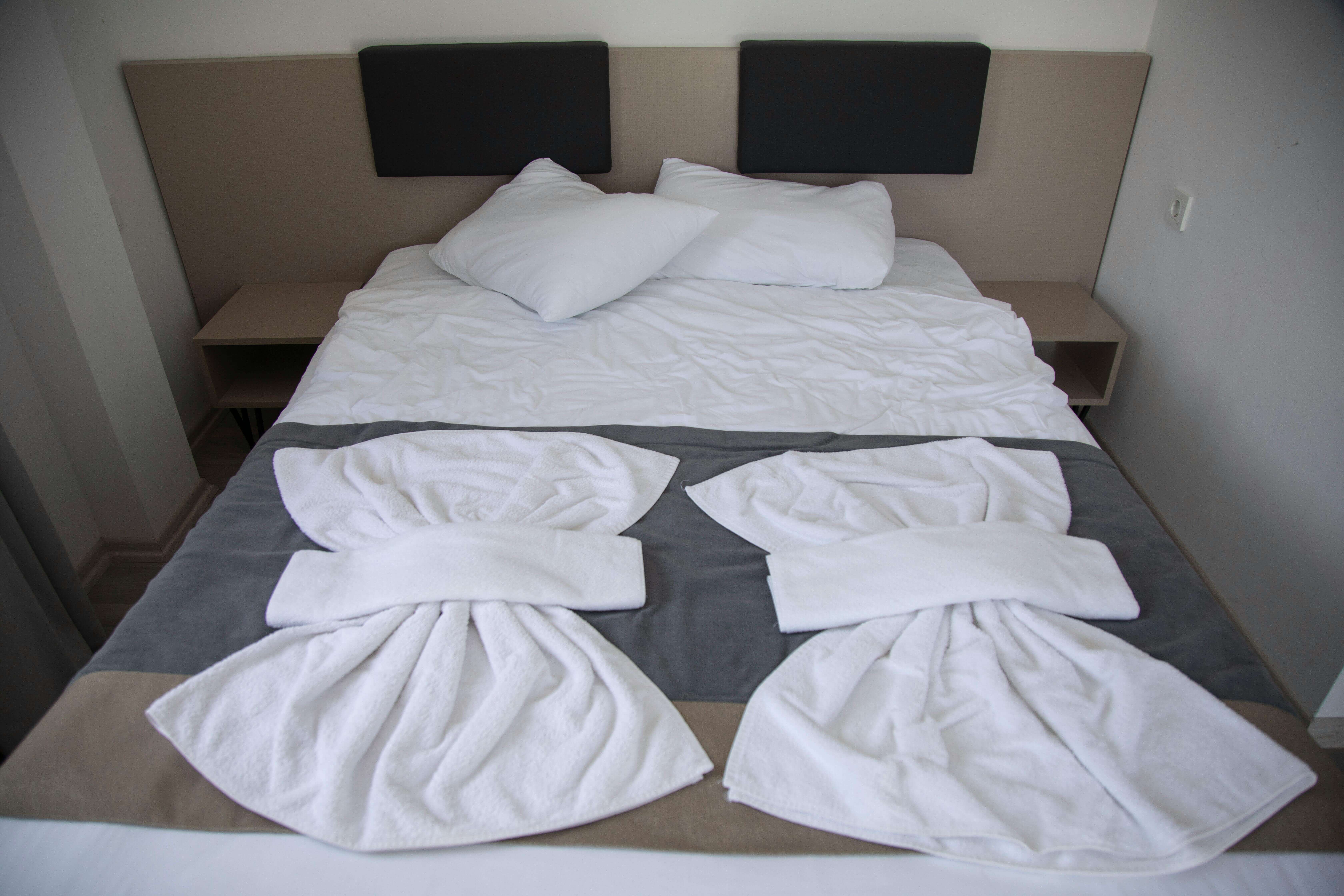 a hotel bed with fresh towels on top