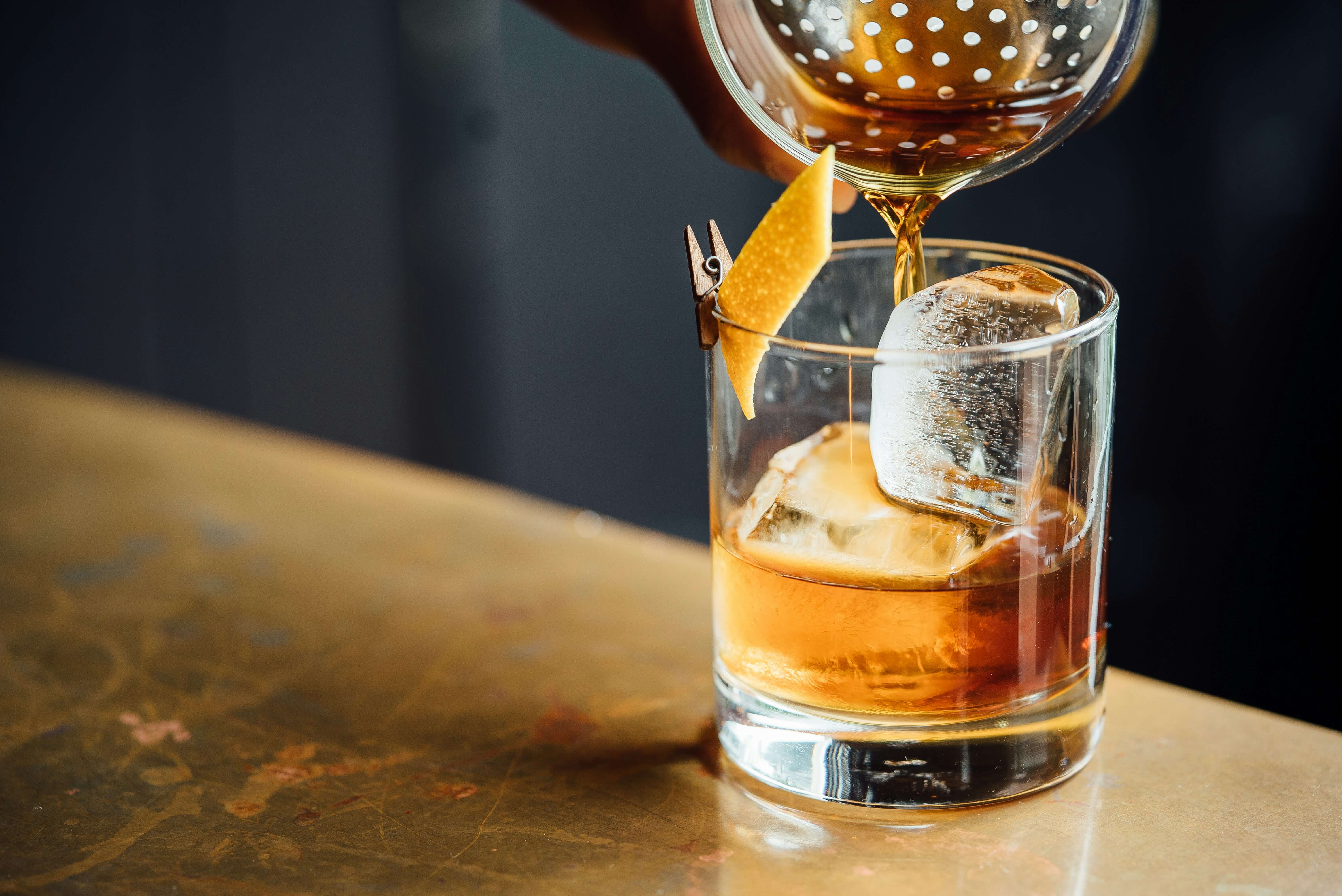 a drink being poured on a bar