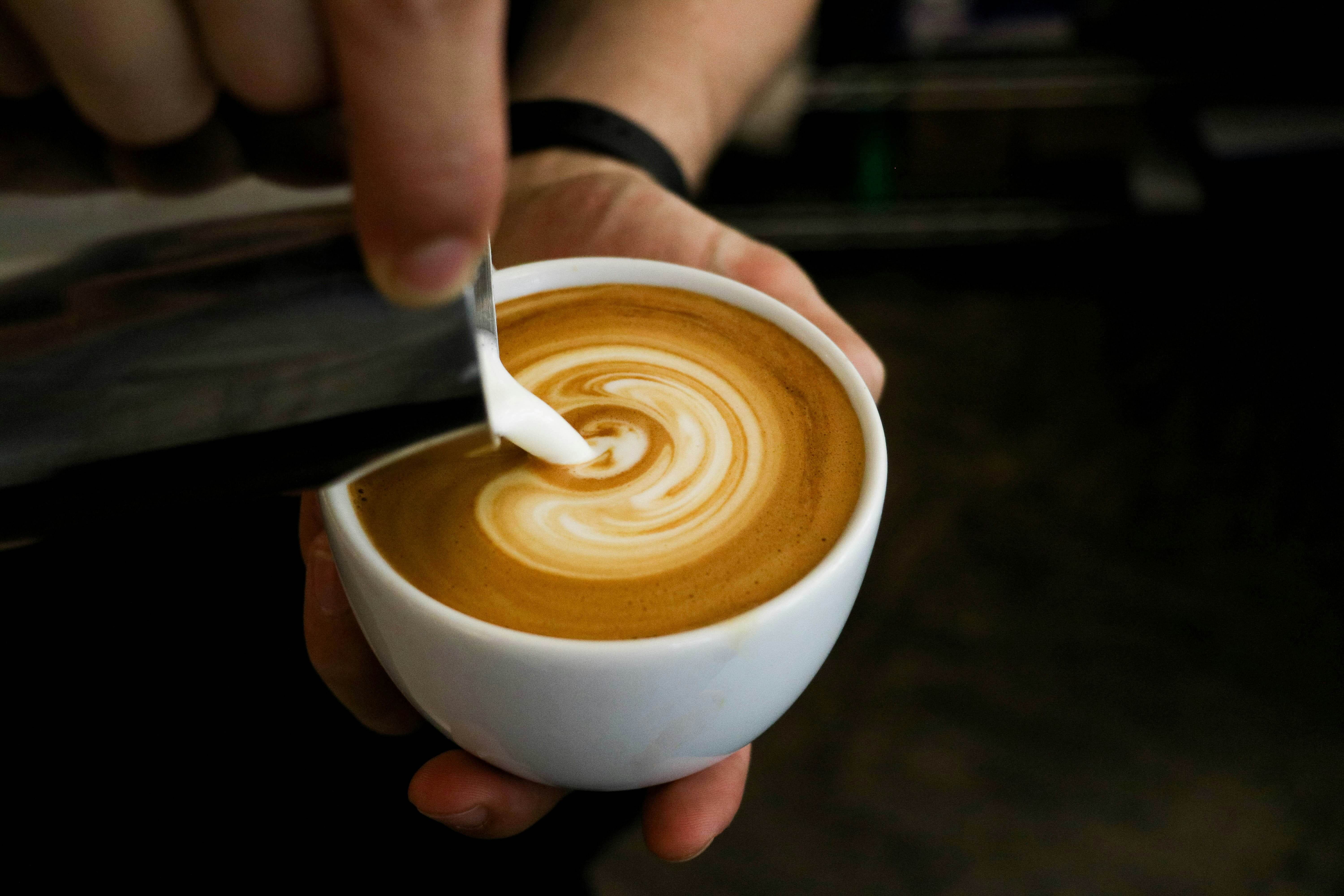 milk being poured into a coffee cup in a coffee shop