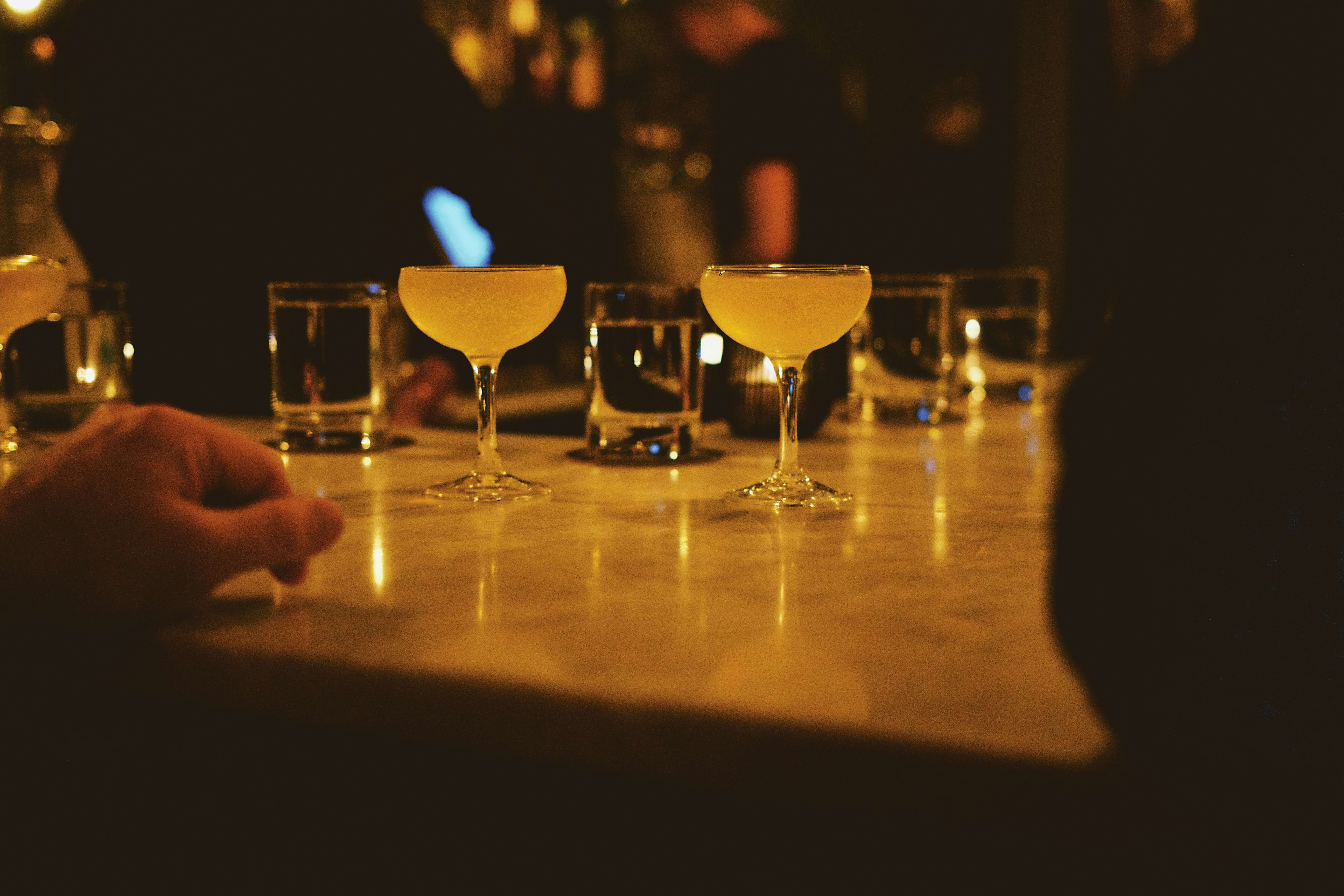 cocktails and glasses on a table in a bar